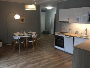 a kitchen with a table and chairs in a kitchen at Apartamenty Silence Baltic Pod Żaglami in Pobierowo