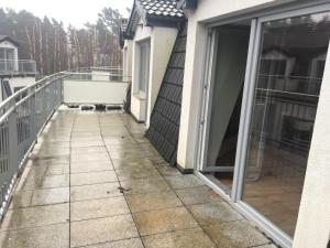 a walkway leading to a balcony with a dog on it at Apartamenty Silence Baltic Pod Żaglami in Pobierowo