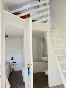 a bathroom with a toilet and a staircase in a room at Hotel Nuit Et Jour - La Maison de Lucile in Cancale