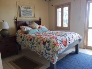 a bedroom with a bed with a floral comforter at Little Indigo Apartments in Mafolie