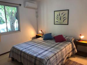 1 dormitorio con 1 cama con 2 almohadas en la casita de colonia 1, en Colonia del Sacramento