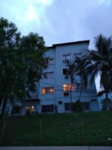 a white building with a palm tree in front of it at Campo Grande Pousar ou morar in Rio de Janeiro