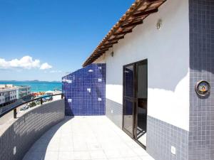 un edificio con azulejos azules en el costado. en Cobertura Duplex na Prainha com Churrasqueira, en Arraial do Cabo