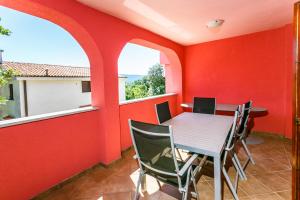 comedor con paredes rojas, mesa y sillas en Apartments Josip, en Pinezici