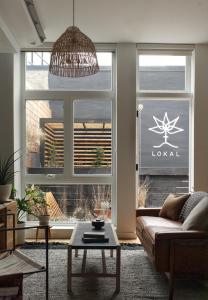 a living room with a couch and a large window at Lokal Hotel Fishtown in Philadelphia