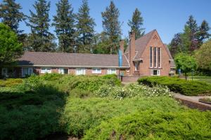 een oud huis met een tuin ervoor bij Fletcher Hotel Restaurant Beekbergen-Apeldoorn in Beekbergen