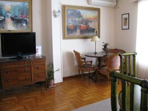 a living room filled with furniture and a tv at Art Gallery Hotel in Athens