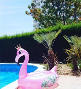 uma estátua de flamingo rosa ao lado de uma piscina em Dream's House em Portimão