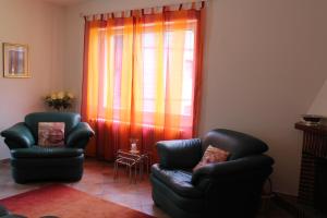 a living room with two chairs and a window at Casa Rosmarino in Gordola