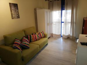 ベナルマデナにあるApartamento Diego Benalmadenaのリビングルーム(緑のソファ、カラフルな枕付)
