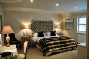 a bedroom with a large bed and a chair at The Red Lion Inn in Babcary