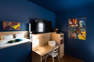 a room with a bed and a desk with a tv at Albergo Residenza Al Teatro in Udine +19 photos
