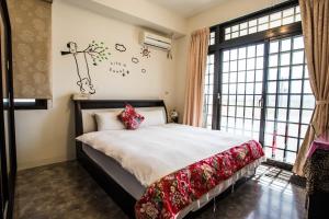 a bedroom with a bed and a large window at Sinmanizu Homestay in Hengchun South Gate