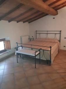 ヴォルタ・マントヴァーナにあるResidence Buca di Baccoのベッドルーム1室(ベッド1台、ベンチ付)