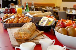 a table topped with baskets of bread and pastries at Chambre d'hôtes Les Herbes Folles in Mauregard