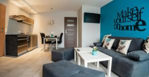 a living room with a couch and a table at Apartamenty TRZY KOLORY in Szklarska Poręba