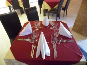a red table with wine glasses and napkins on it at Hotel Amigos in Obzor