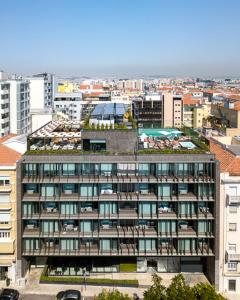 an apartment building with a green roof in a city at Lux Lisboa Park in Lisbon