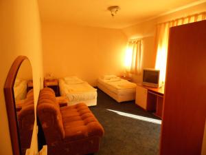 a hotel room with two beds and a couch at Hotel Amigos in Obzor