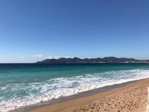 a view of the beach with mountains in the background at Villa Tricia Cannes in Cannes