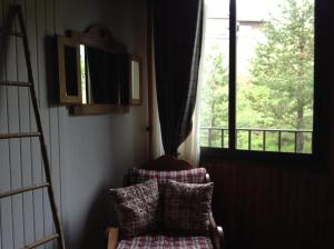 a living room with a chair and a window at Hôtel Boule de Neige in Gourette