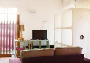 ein Wohnzimmer mit einem Sofa und einem TV in der Unterkunft La Pigna in Cervia