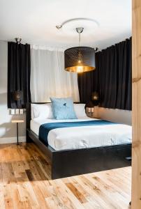 a bedroom with a large bed with black curtains at Capitol Robinson by Bower Boutique Hotels in Moncton