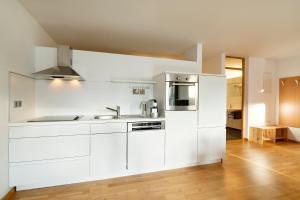 a white kitchen with a sink and a refrigerator at Ferienwohnung iq-Sports in Bludenz