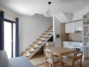 a kitchen with a staircase with a table and chairs at Marina Palmanova Apartamentos in Palmanova