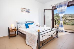 1 dormitorio con cama y ventana grande en Blue Horizon Apartment, en Kalathos