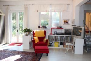 a living room with a red chair and a tv at Bed & Breakfast Wesseloh in Schneverdingen