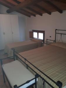 ヴォルタ・マントヴァーナにあるResidence Buca di Baccoのベッド3台と窓が備わる客室です。