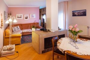 a living room with a couch a table and a fireplace at Casa Caterina in Fiera di Primiero