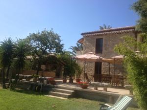 ein Haus mit einer Terrasse und einem Hof in der Unterkunft B&B L'Oasi in SantʼAndrea Apostolo dello Ionio