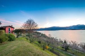 une maison sur une colline à côté d'une grande étendue d'eau dans l'établissement Locanda Pozzetto, à Laveno-Mombello