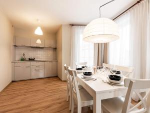 - une salle à manger blanche avec une table et des chaises blanches dans l'établissement VacationClub – Olymp Apartament 211, à Kołobrzeg