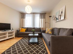 a living room with a couch and a tv at VacationClub – Olymp Apartament 211 in Kołobrzeg