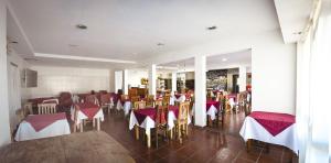 a restaurant with red and white tables and chairs at La Candida Hotel in Merlo