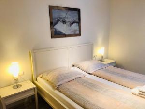 Sankt Stefan an der GailにあるAssingerhofのベッド2台、ランプ2つ(テーブル付)が備わる客室です。
