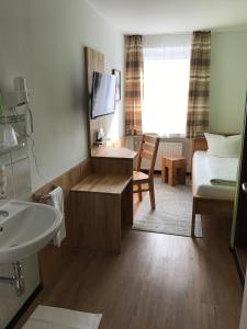 a bathroom with a sink and a bed and a mirror at Hotel Luitpold in Landshut