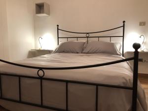 un letto con struttura nera e lenzuola e cuscini bianchi di Il Pendio a Castellaneta