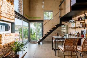 ein Raum mit einem Tisch und Stühlen und einer Treppe in der Unterkunft El Risco del Lomero, chimenea 4 Huesp max in Valdelarco