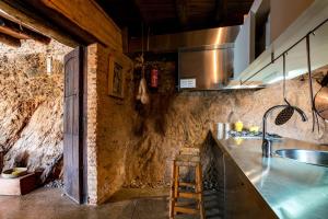 eine Küche mit einer Theke und einem Waschbecken in einem Zimmer in der Unterkunft El Risco del Lomero, chimenea 4 Huesp max in Valdelarco + 75 Fotos