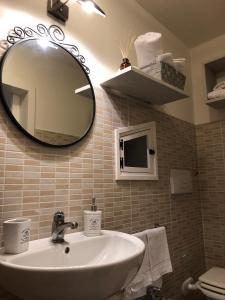 een badkamer met een wastafel en een spiegel bij Il Pendio in Castellaneta