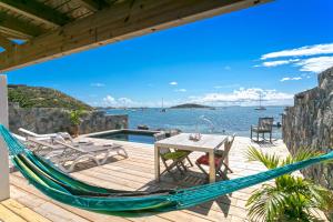 a hammock on a deck with a view of the water at MA CABANE PIEDS DANS L EAU in Cul de Sac