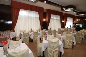 sala bankietowa z białymi stołami i białymi krzesłami w obiekcie hotel ristorante vittoria w mieście Santhià