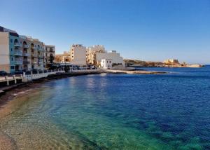 a view of a beach with buildings and the water at Diamonds Luxury Apartments in Marsalforn