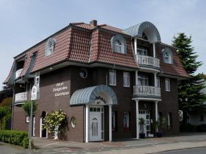 un bâtiment en briques rouges avec un toit rouge dans l'établissement Hotel Diekgerdes, Komfortzimmer, à Cloppenburg