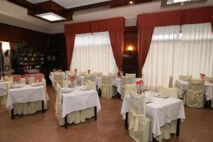 桑特伊阿的住宿－hotel ristorante vittoria，宴会厅配有带白色桌布的桌子