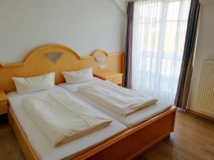 Aparthotel "Zum Gutshof" في Hohenwarth: سرير كبير في غرفة نوم مع نافذة كبيرة